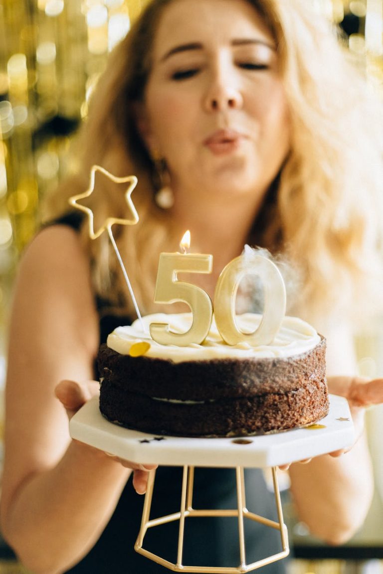 woman in black top holding white and black cake